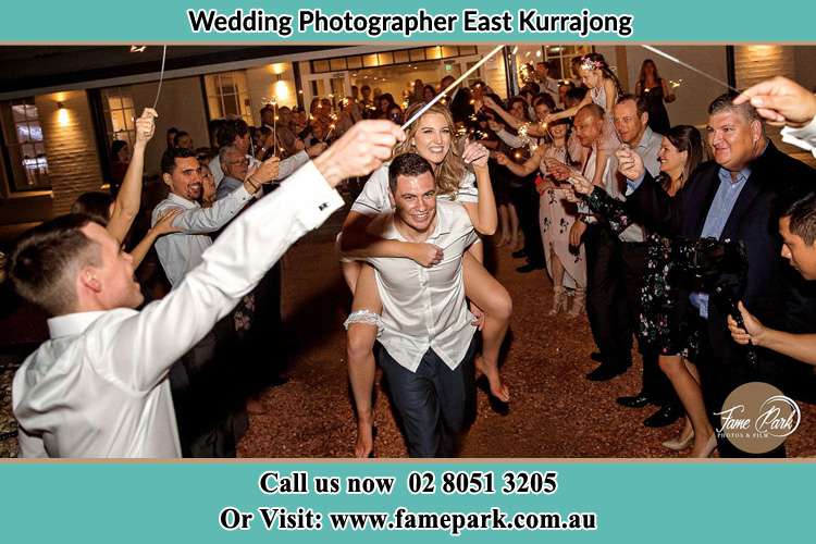 The Groom carrying her Bride while while the crowd cheering them East Kurrajong NSW 2758