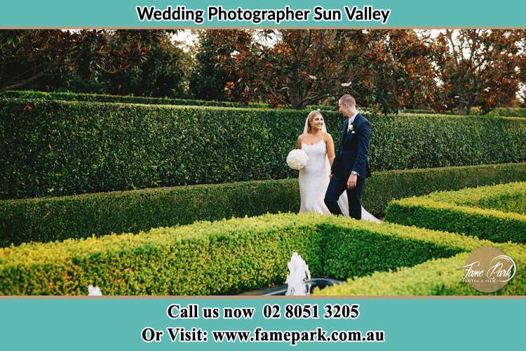 Photo of the Bride and the Groom walking on the garden Sun Valley